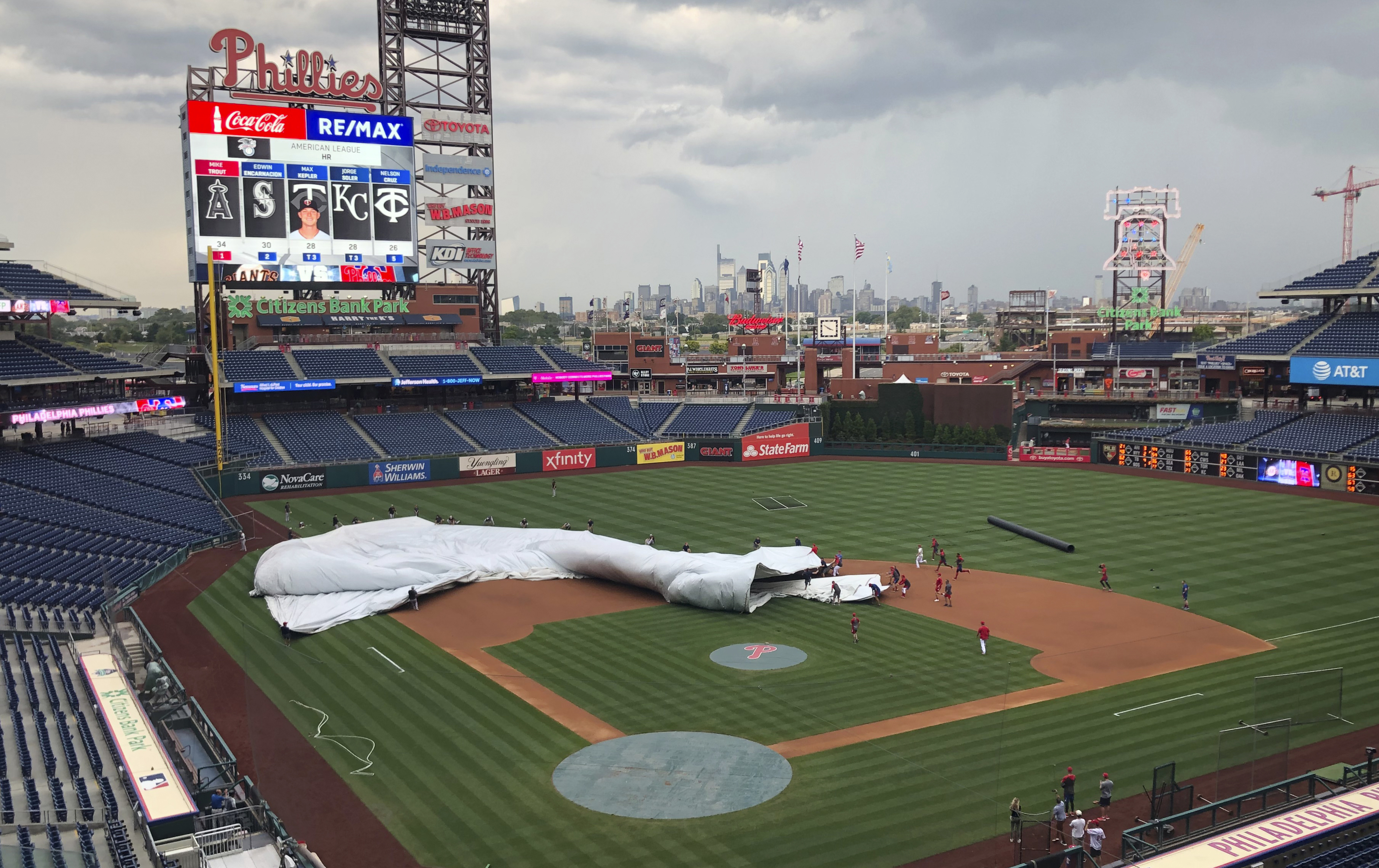 Giants, Phillies players help corral wind-blown tarp